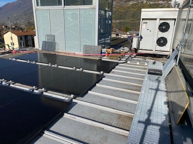 Moduli fotovoltaici posati in copertura accanto alle unità di climatizzazione